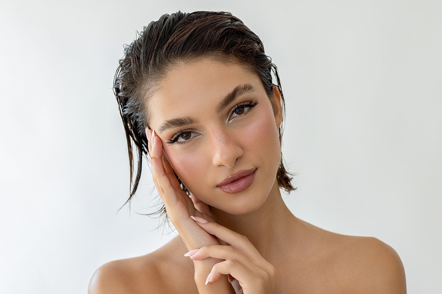 Young Lafayette facial plastic surgery model with fresh makeup against neutral background.