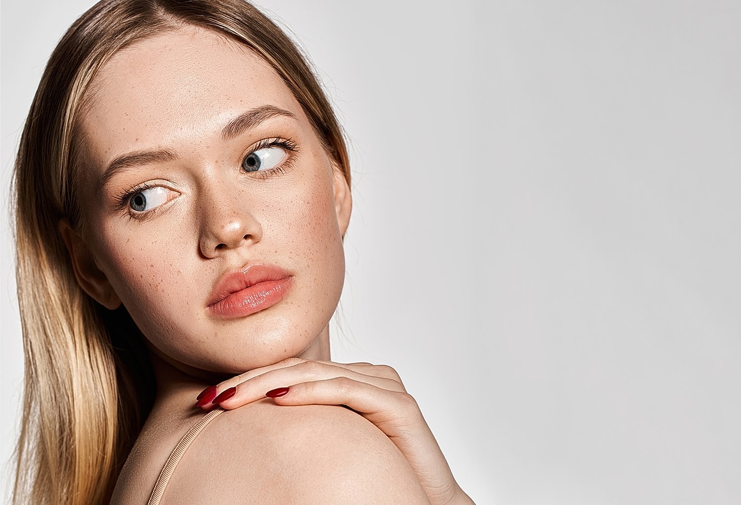 Young Lafayette facial plastic surgery model with long hair, studio portrait.