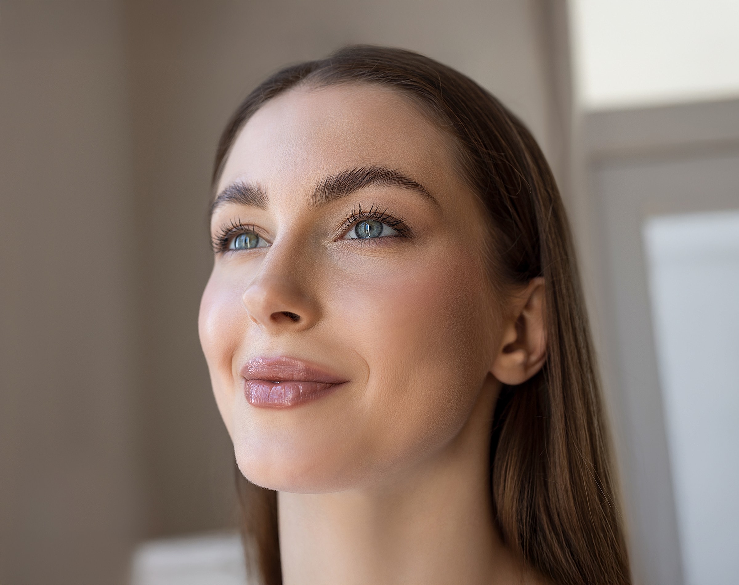Smiling Lafayette facial plastic surgery model with long hair and bright eyes.